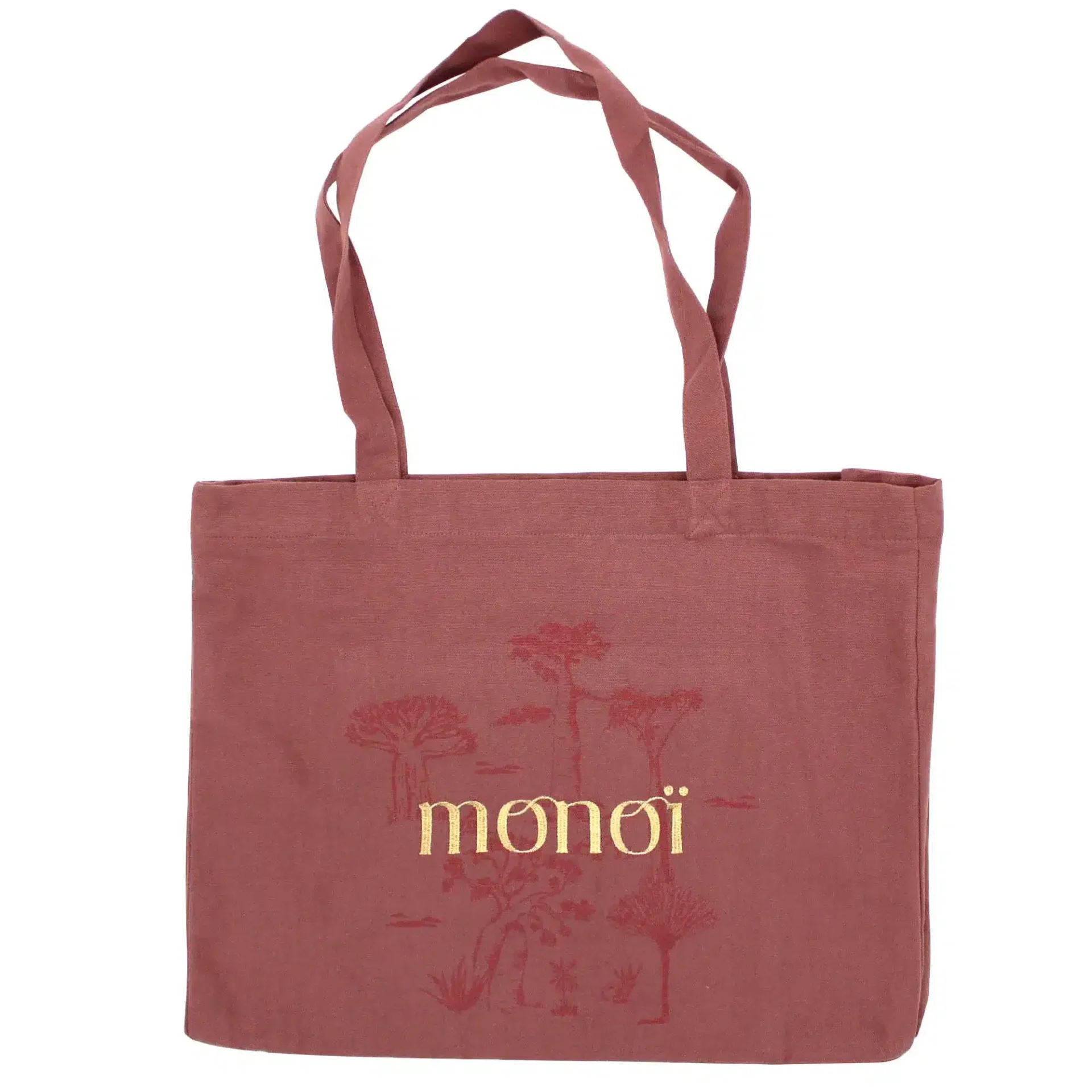 Un cabas marron avec deux anses et le mot « monoï » brodé en jaune ainsi que des motifs décoratifs en fond.
